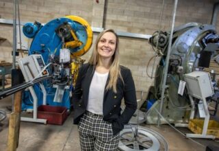 Laura Clarke from Chilwell Products standing with a machine